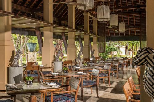 um restaurante vazio com mesas e cadeiras de madeira em Four Seasons Resort Langkawi em Tanjung Rhu