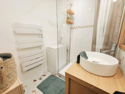 a white bathroom with a sink and a shower at Le Cosy Les Pieds Dans L'eau in Le Grau-du-Roi
