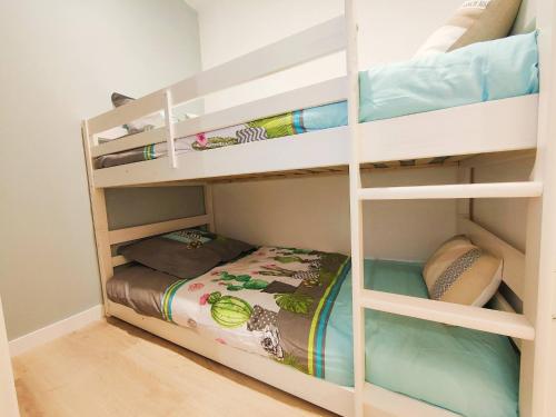 a bedroom with bunk beds with a bed in it at Le Cosy Les Pieds Dans L'eau in Le Grau-du-Roi