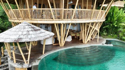 a house with a deck and a swimming pool at Villas Bukit Lipah in Amed