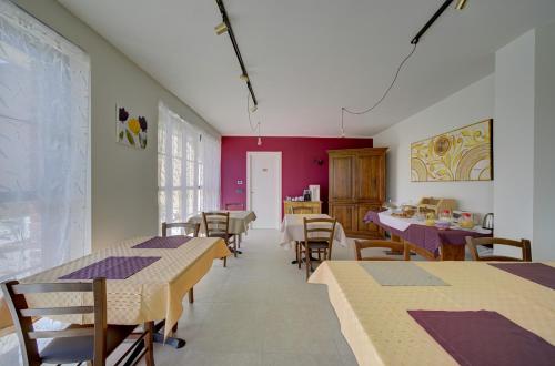 a dining room with tables and chairs and red walls at Il Roseto dei Sensi in Tarantasca