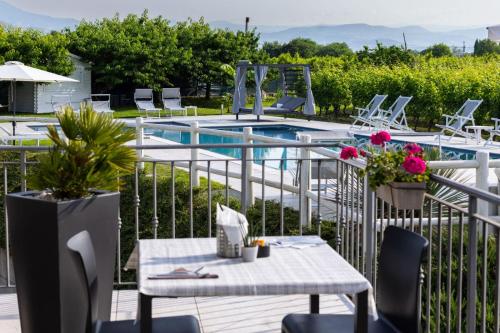 a patio with a table and chairs next to a pool at Agriturismo La Torretta in Pescantina
