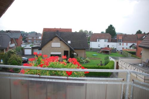 a view of a house with red flowers on a balcony at Gästehaus Stillecke in Erwitte