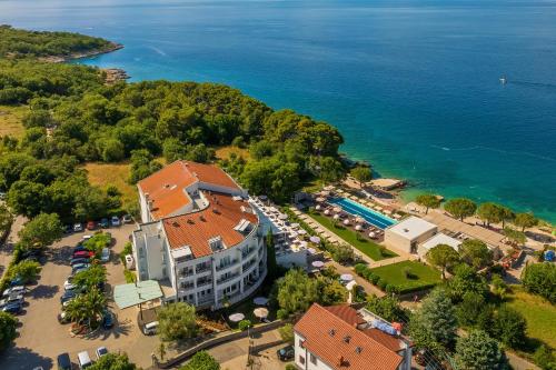 an aerial view of a hotel with a parking lot and the water at Spa & Wellness Hotel Pinia in Malinska
