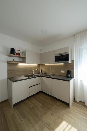 a kitchen with white cabinets and a black counter top at Villa Betty Apartments in Arco