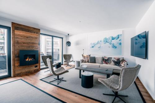a living room with a couch and chairs and a fireplace at Navigare Resorts in Saas-Fee
