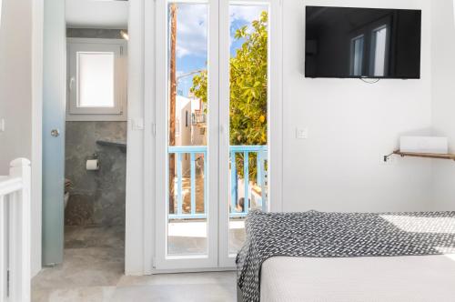 Camera con porta scorrevole in vetro e TV di Panda Blue&White Downtown a Megali Ammos