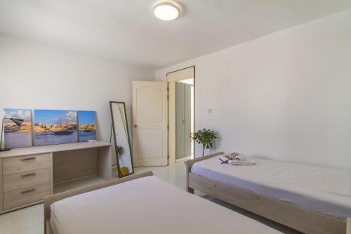 a bedroom with two beds and a flat screen tv at Swieqi Stay with Shared Facilities 107 in Is-Swieqi