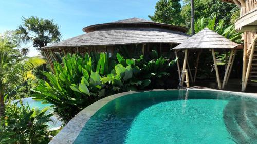a swimming pool with a gazebo next to a house at Villas Bukit Lipah in Amed