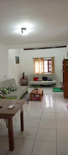 a living room with two couches and a table at Oásis Flórida in Peruíbe
