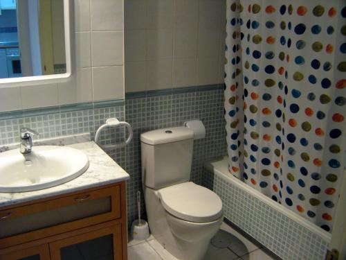 a bathroom with a toilet and a sink and a shower curtain at Apartamento VenAVera Playa Jardines de Nuevo Vera L1-2E Ático Primera Línea WIFI in Vera