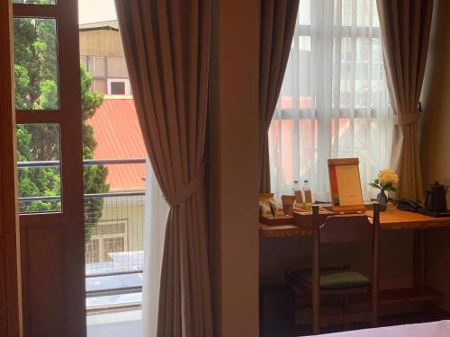 a room with a desk in front of a window at The Pink Boutique Hotel in Da Lat