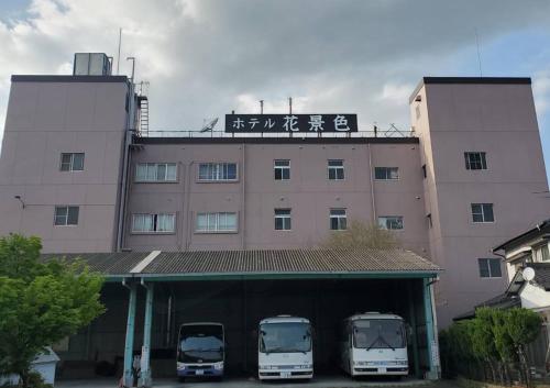 three buses parked in front of a building at Hotel Hanagesiki in Ukiha