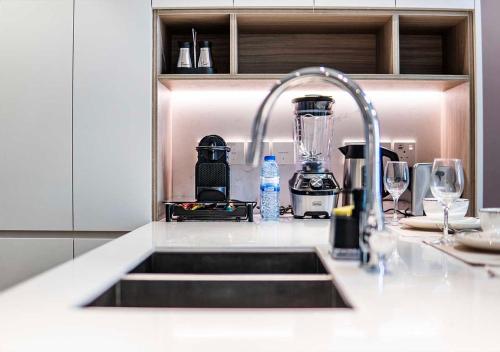 a kitchen sink with a faucet in a kitchen at Royal Vista - Luxury 1BR Apartments at Kensington Waters in Dubai