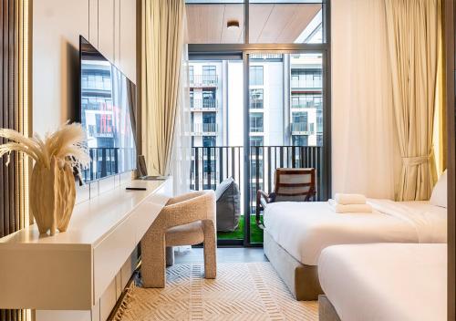 a hotel room with two beds and a balcony at Royal Vista - Luxury 1BR Apartments at Kensington Waters in Dubai