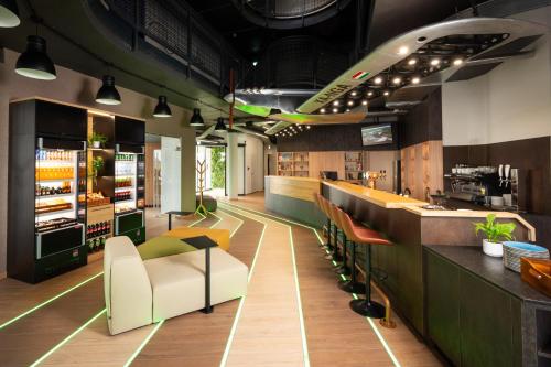 a restaurant with a bar with chairs and tables at ibis Styles Debrecen Airport in Debrecen