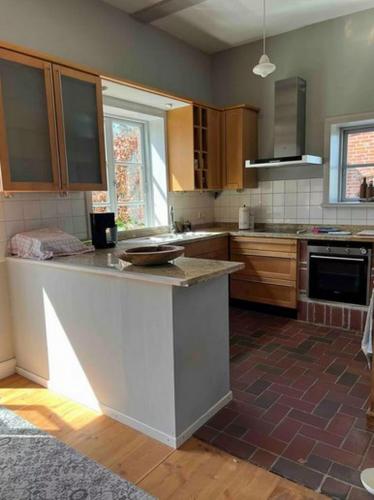 a kitchen with wooden cabinets and a counter top at Kutscherremise Gut Niendorf - ABC592 - nur Feriengäste! in Bad Kleinen