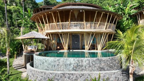 a resort with a swimming pool and a building at Villas Bukit Lipah in Amed