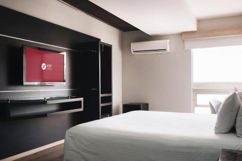 a bedroom with a bed and a flat screen tv at Exe Cities Reforma in Mexico City