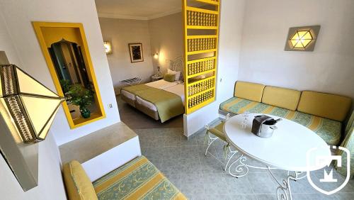 a hotel room with a bed and a couch and a table at Hotel La Residence Hammamet in Hammamet