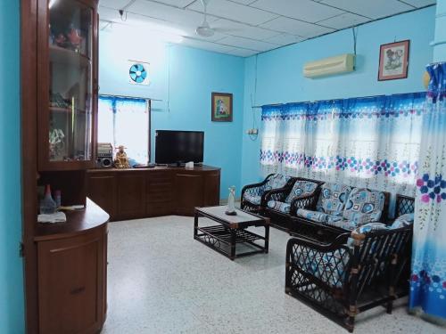 a living room with a couch and a tv at 51 SpS HOMES in Bagan Serai