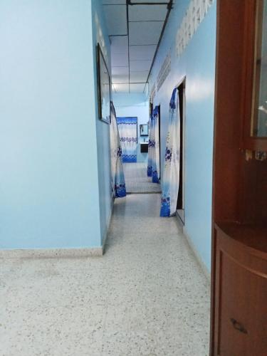a hallway in an office with blue walls and white floors at 51 SpS HOMES in Bagan Serai