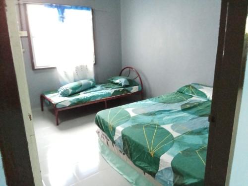 a bedroom with a bed and a window and a bench at 51 SpS HOMES in Bagan Serai
