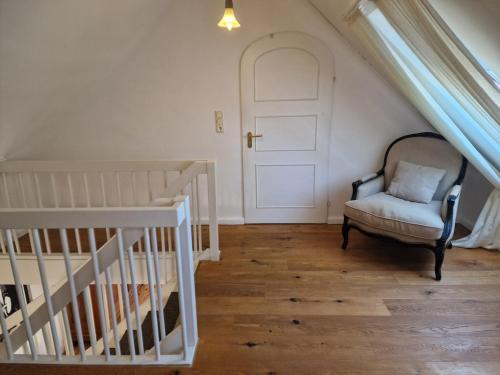 a stair room with a chair and a white door at Ferienhaus Lisette Wohlfühldomizil zwischen Rebenmeer und Pfälzer Wald in Haßloch