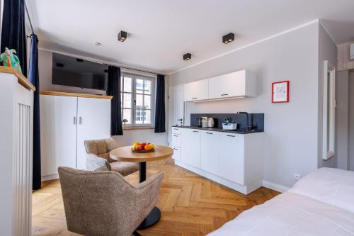 a room with a bed and a table and a kitchen at Logierhaus RheintorEins in Rees
