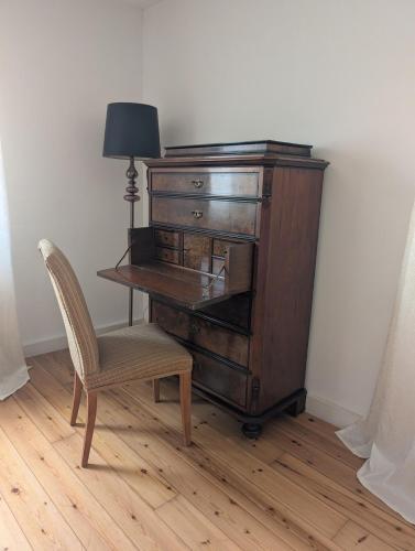 an old wooden desk with a chair and a lamp at Ferienhaus Lisette Wohlfühldomizil zwischen Rebenmeer und Pfälzer Wald in Haßloch