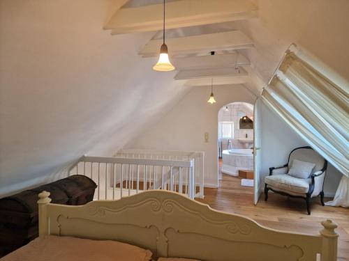 a bedroom with a crib and a chair in a room at Ferienhaus Lisette Wohlfühldomizil zwischen Rebenmeer und Pfälzer Wald in Haßloch
