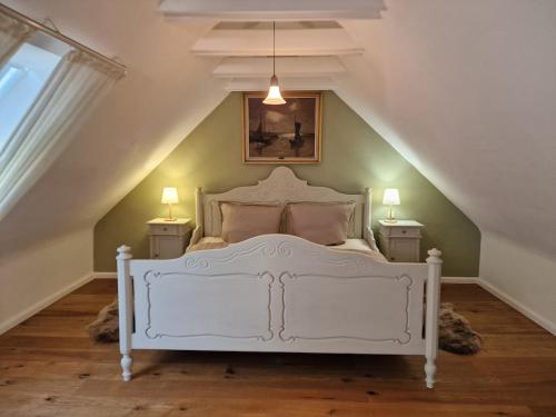a bedroom with a white bed in a attic at Ferienhaus Lisette Wohlfühldomizil zwischen Rebenmeer und Pfälzer Wald in Haßloch