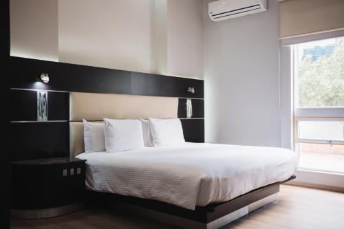 a bedroom with a large bed with a black headboard at Exe Cities Reforma in Mexico City