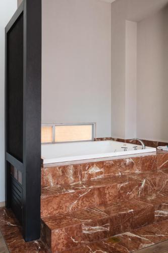 a living room with a large stone wall and a television at Exe Cities Reforma in Mexico City
