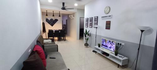 a living room with a couch and a tv at Hana Pekan Pahang Homestay 3room in Pekan