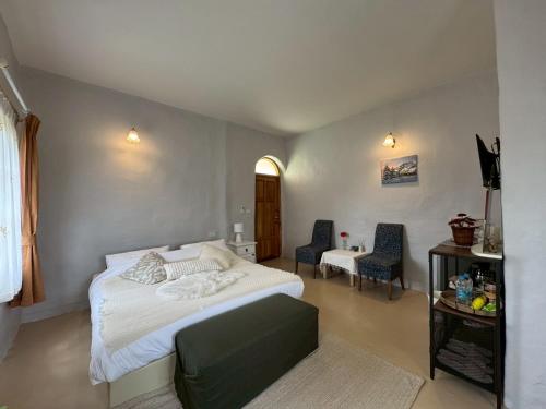 a bedroom with a bed and a table and chairs at Pundin Khaoyai in Nong Sarai