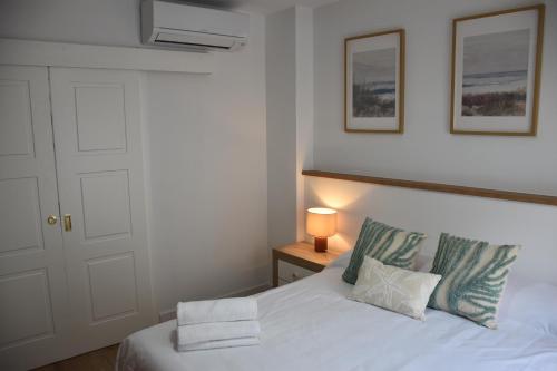 ein Schlafzimmer mit einem weißen Bett und zwei Kissen in der Unterkunft Apartamento Sol de Maro in Maro