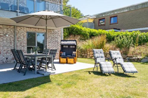 una mesa y sillas bajo una sombrilla en un patio en Haus Seeblick Bosau Abendröte, en Bosau