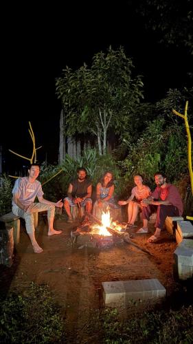 a group of people sitting around a fire at night at The Blue House in Pelling