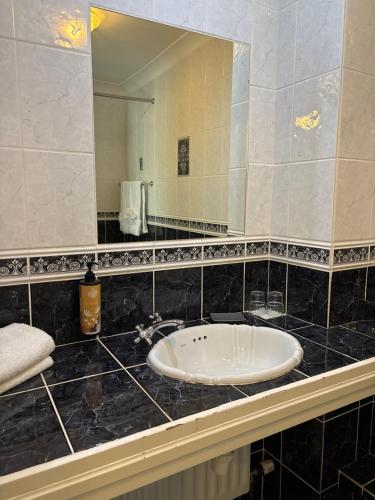 a bathroom with a sink and a large mirror at The Fincourt B&B in Oldcastle