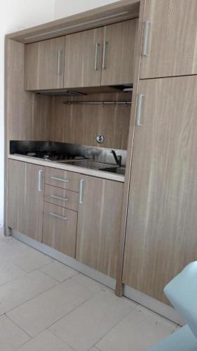 a kitchen with wooden cabinets and a sink at VirgolaZero1 in Porto Potenza Picena