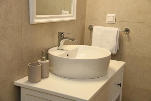 a bathroom with a white sink and a mirror at Andros Neoclassical Villa NP1926 with Private Pool in Steniaí