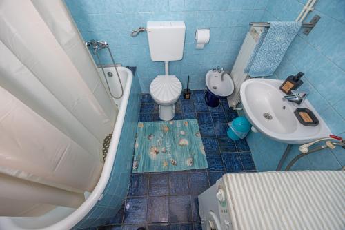 een badkamer met een bad, een toilet en een wastafel bij MICIKA Country house in Grižane