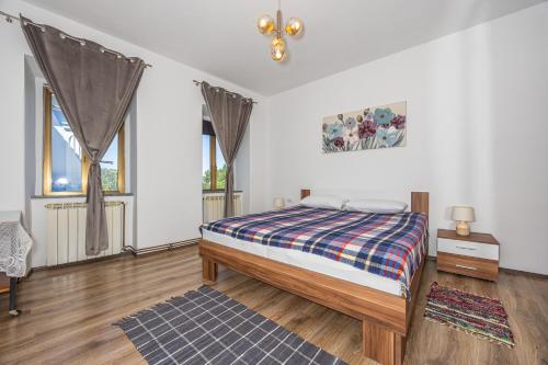 een slaapkamer met een bed en twee ramen bij MICIKA Country house in Grižane