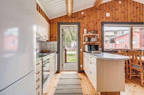 a kitchen with wooden walls and a wooden floor at Bruksvallslidens förmedling in Bruksvallarna