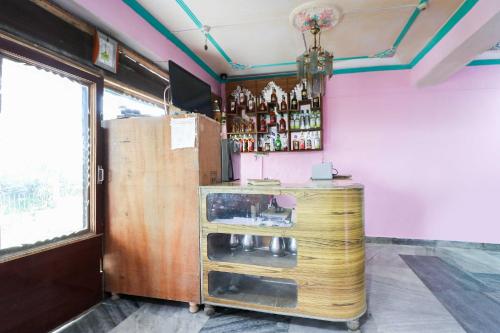 a bar with a wooden counter and a window at Hotel O Dp Bar in Rāmpur