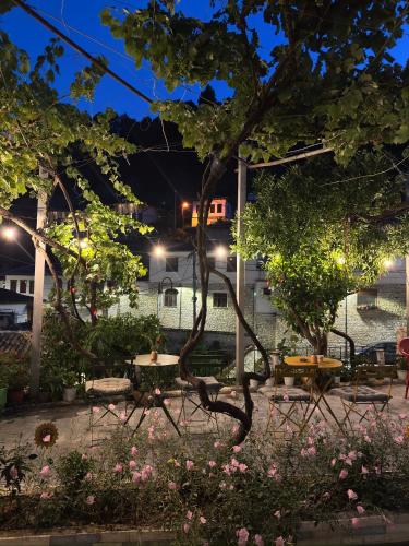a courtyard with tables and trees at night at Nika's Guest House in Berat