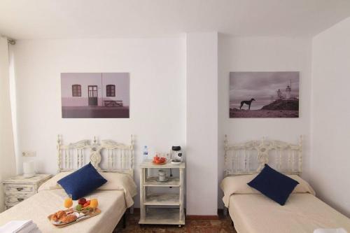 a bedroom with two beds with blue pillows at Casa Cándida in Almería