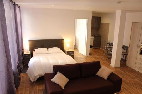 a large bedroom with a bed and a couch at Hôtel Le 43 in Luxeuil-les-Bains