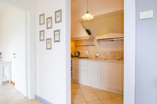 a kitchen with white cabinets and a sink at fantastic lake view and pool, Primo sole in Barcuzzi